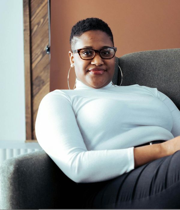 Person sitting comfortably in a bright room, looking relaxed.